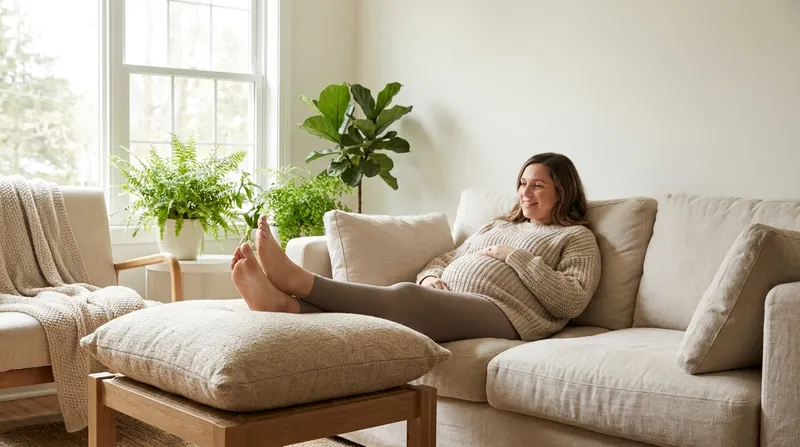 Pregnant woman resting on a sofa with her legs elevated on a cushion