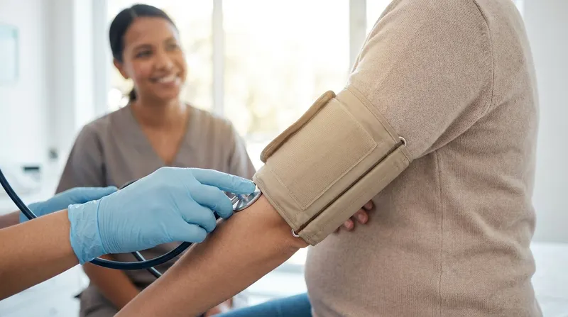 A pregnant woman having her blood pressure measured with an upper-arm cuff during a routine prenatal check-up